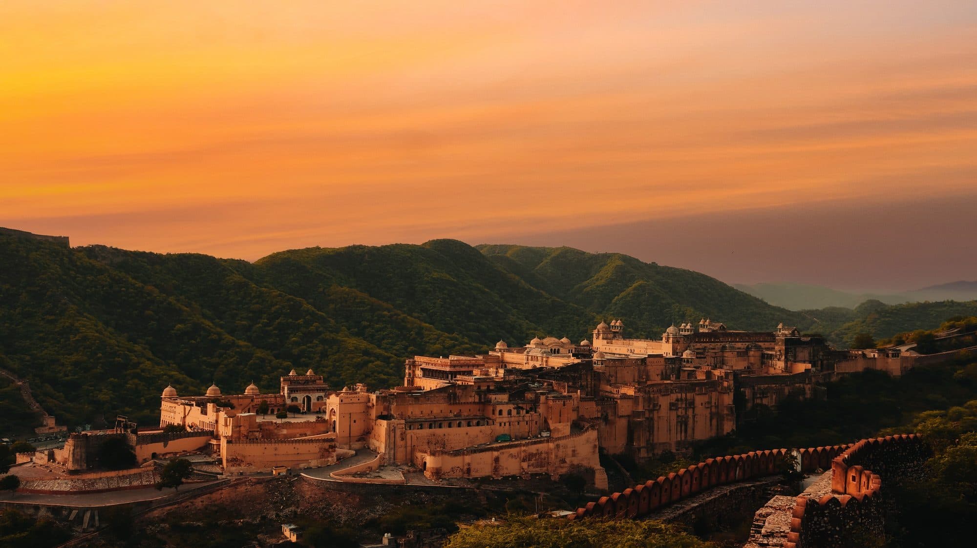 Amer Fort near Jaipur at sunset, with the Aravalli hills and fort walls behind