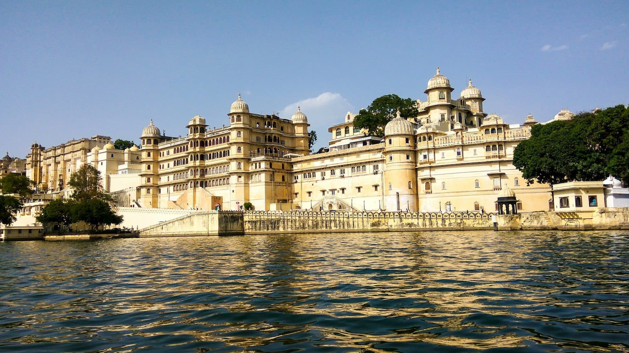 City Palace in Udaipur on the shore of Lake Pichola under a clear blue sky